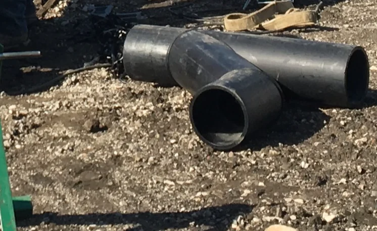Cút hàn HDPE và tê HDPE màu đen đặt tại công trường trước khi hàn nối đầu vào tuyến ống
